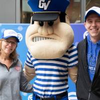 Two alumni pose with Louie the Laker at the Detroit Red Wings GVSU Night